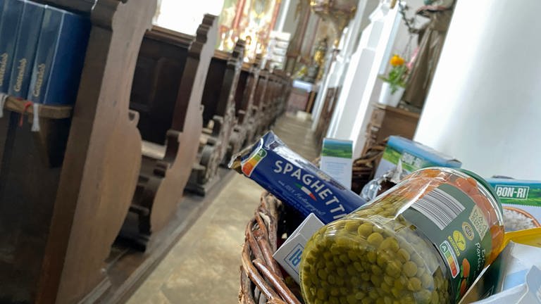  Ein Korb mit Lebensmitteln in einer Kirche. Körbe gefüllt mit Lebensmitteln gibt es für Bedürftige in der katholischen Kirche St. Martinus in Niederstotzingen im Kreis Heidenheim.